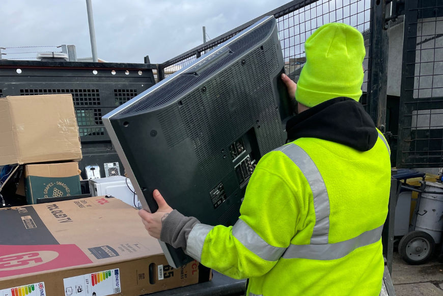 Waste worker disposing of electrical items 